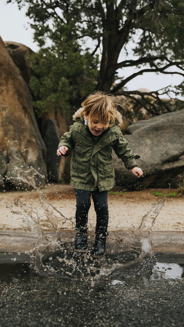 child jumping in a puddle